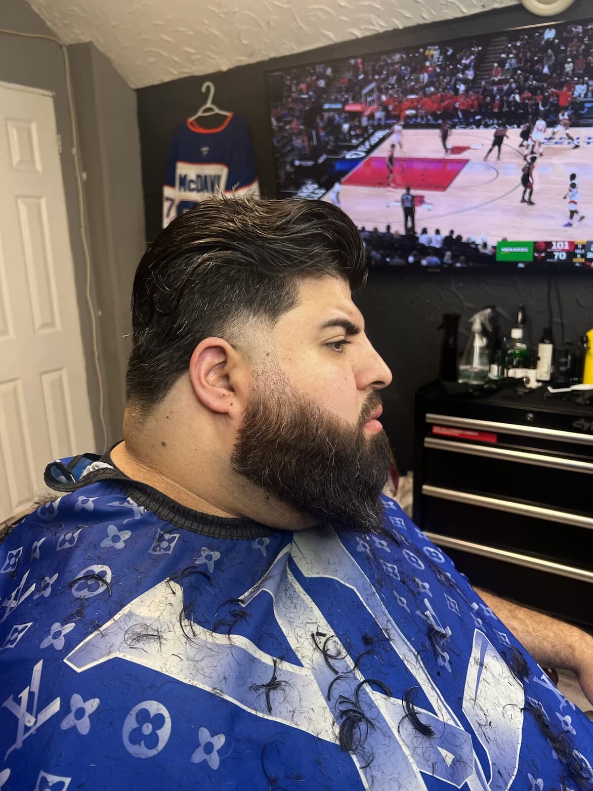 Low fade with a longer flowing top and full beard