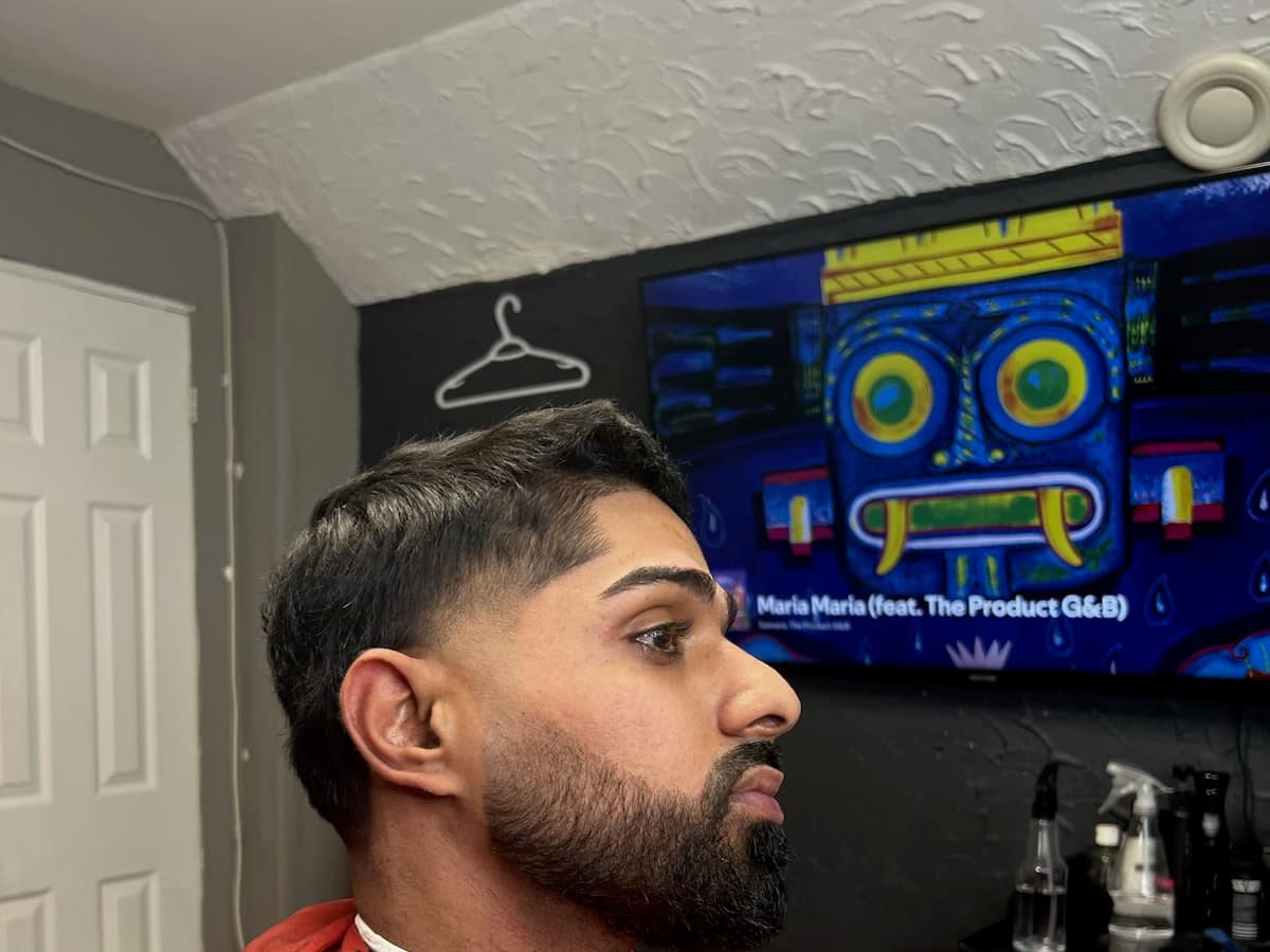 Taper with a hard line-up across the forehead and the beard edged to the jaw